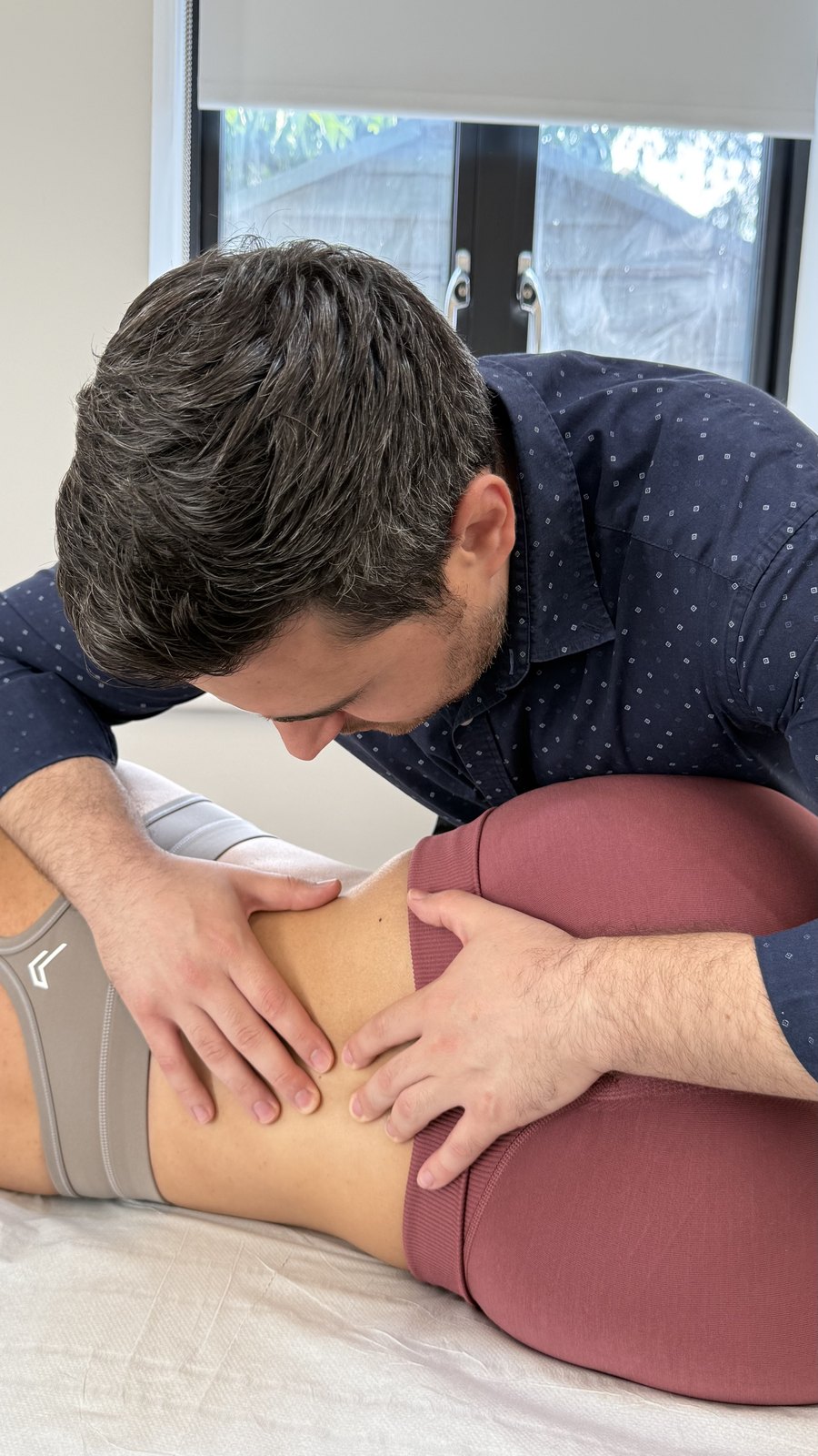 Physiotherapist providing hands-on manual therapy to a patient's lower back and hip