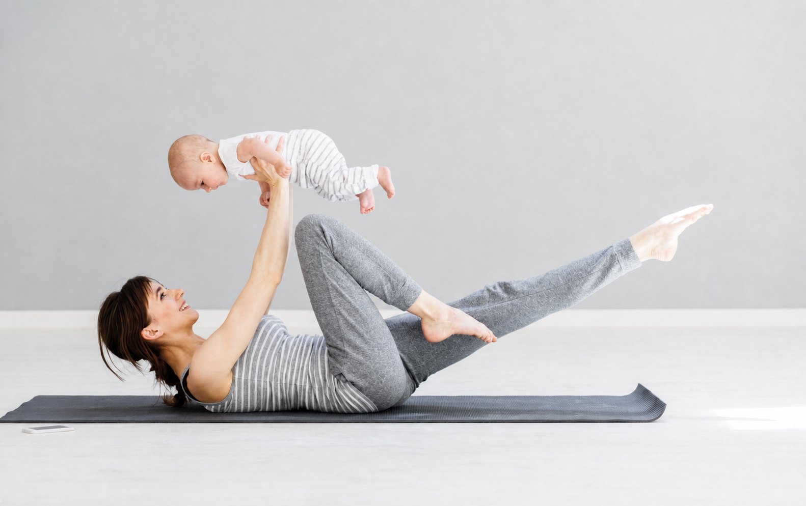 Mother exercising with her baby during postnatal rehabilitation
