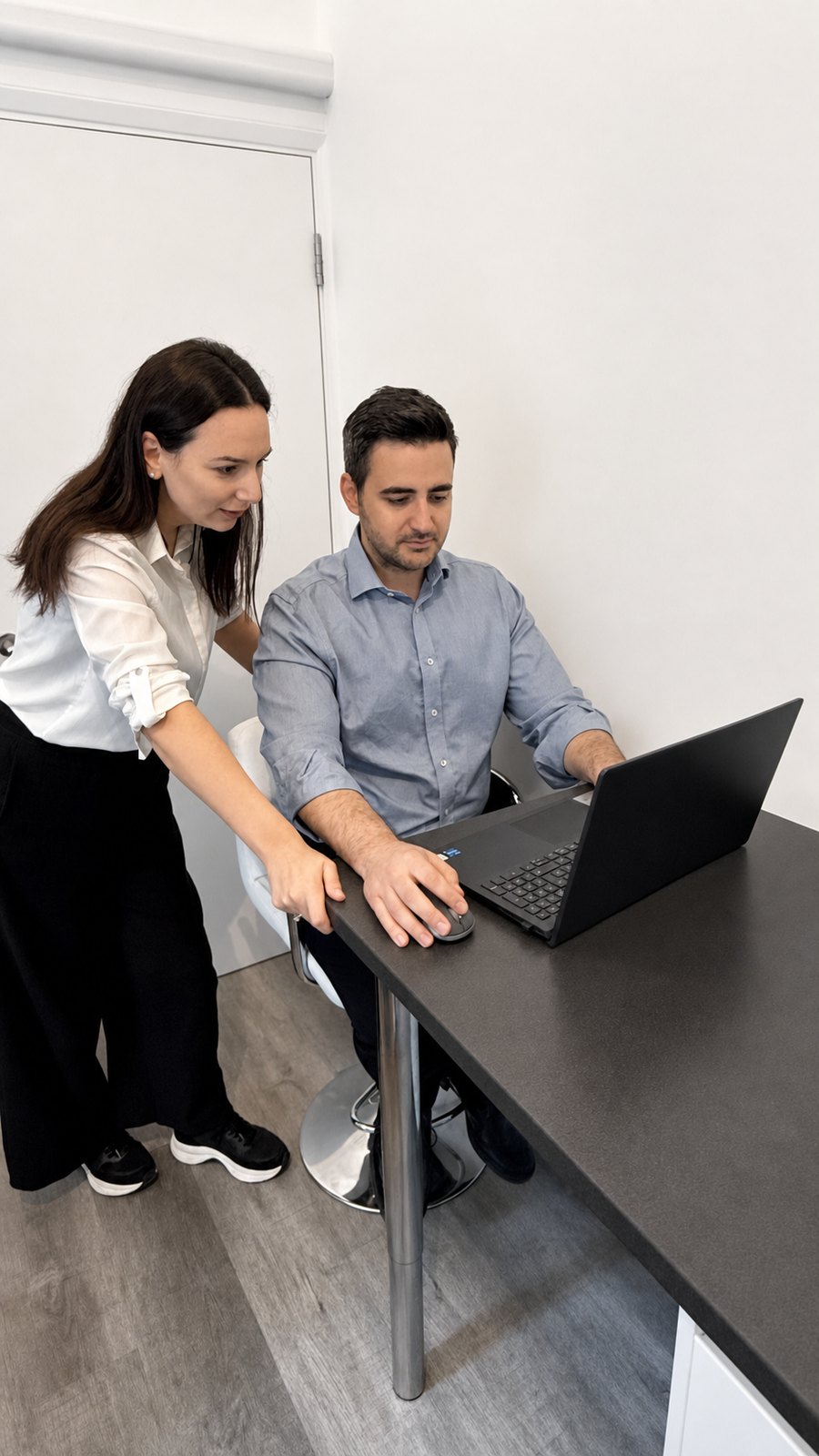 Two physiotherapists reviewing a sports rehabilitation plan on a laptop